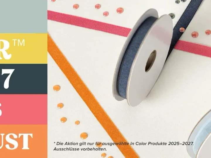 Auf einem weißen Hintergrund liegen zwei Spulen mit Seidenband in Blau und Hellblau diagonal über farbigen Streifen in Gelb, Orange, Pink und Grau. Kleine glänzende Konfetti-Flecken in verschiedenen Farben sind verstreut auf dem Papier verteilt.