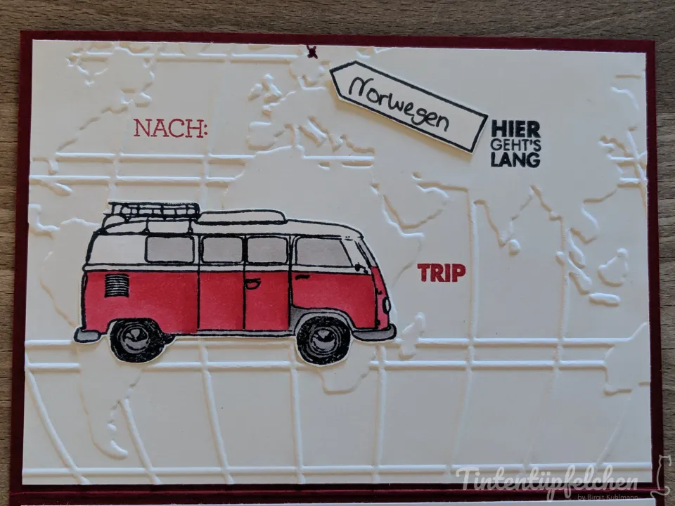 Eine Karte mit einem roten Bulli auf einer geprägten Weltkarte. Ein Pfeilschild zeigt nach Norwegen, ein weiteres sagt "Hier geht's lang".