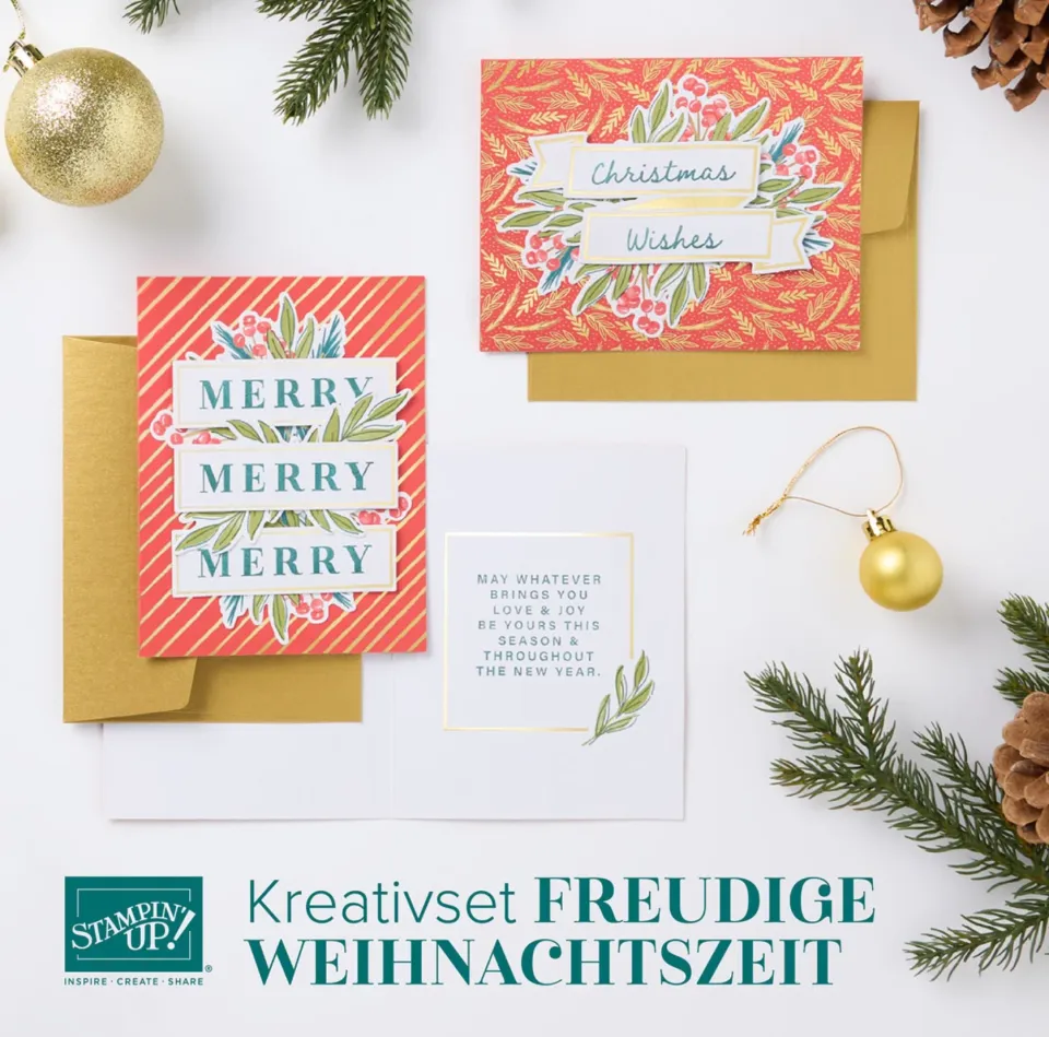 Drei Weihnachtskarten mit gestempelten Motiven und Texten in Rot, Grün und Gold liegen auf weißem Hintergrund um goldene Umschläge herum. Dekorative Elemente wie Tannenzweige, Kiefernnadeln und glänzende Goldkugeln ergänzen die Szene. Der untere Bereich zeigt das Logo von Stampin’ Up! zusammen mit der Beschriftung „Kreativset FREUDIGE WEIHNACHTSZEIT“ in grüner Schrift.