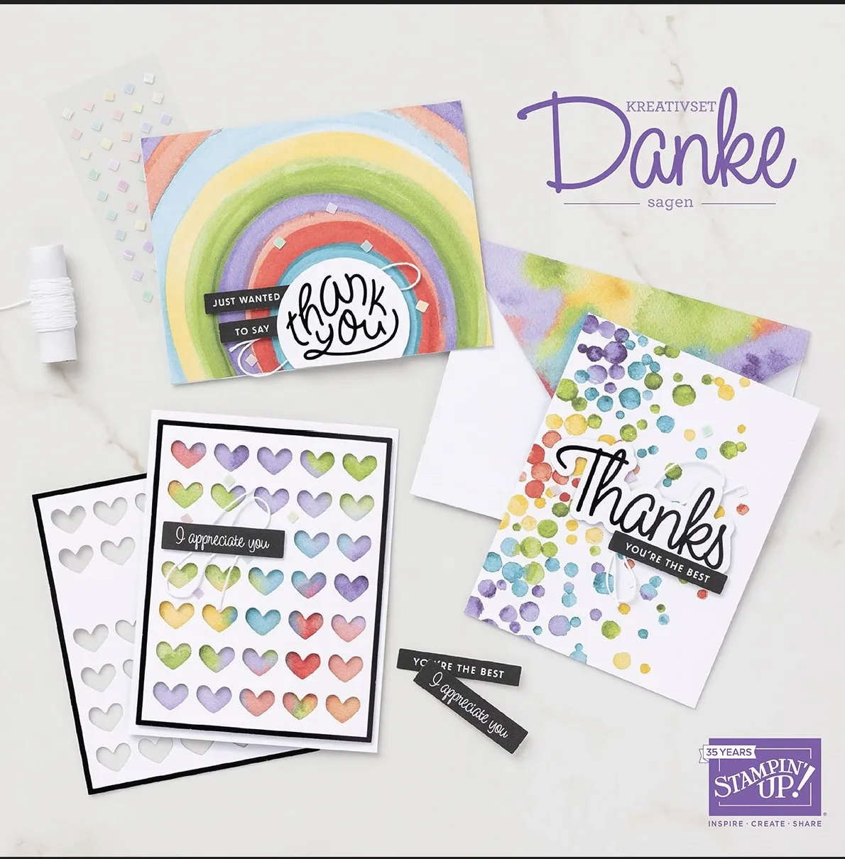 Vielfältige gestempelte Dankeskarten mit Regenbogen- und Farbpunktmotiven, darunter eine Karte mit abgerundeten Herzen in Pastellfarben und eine andere mit „Thank you“ in schwarzer Schrift auf weißem Grund, begleitet von Stempelsets und Zierstreifen.