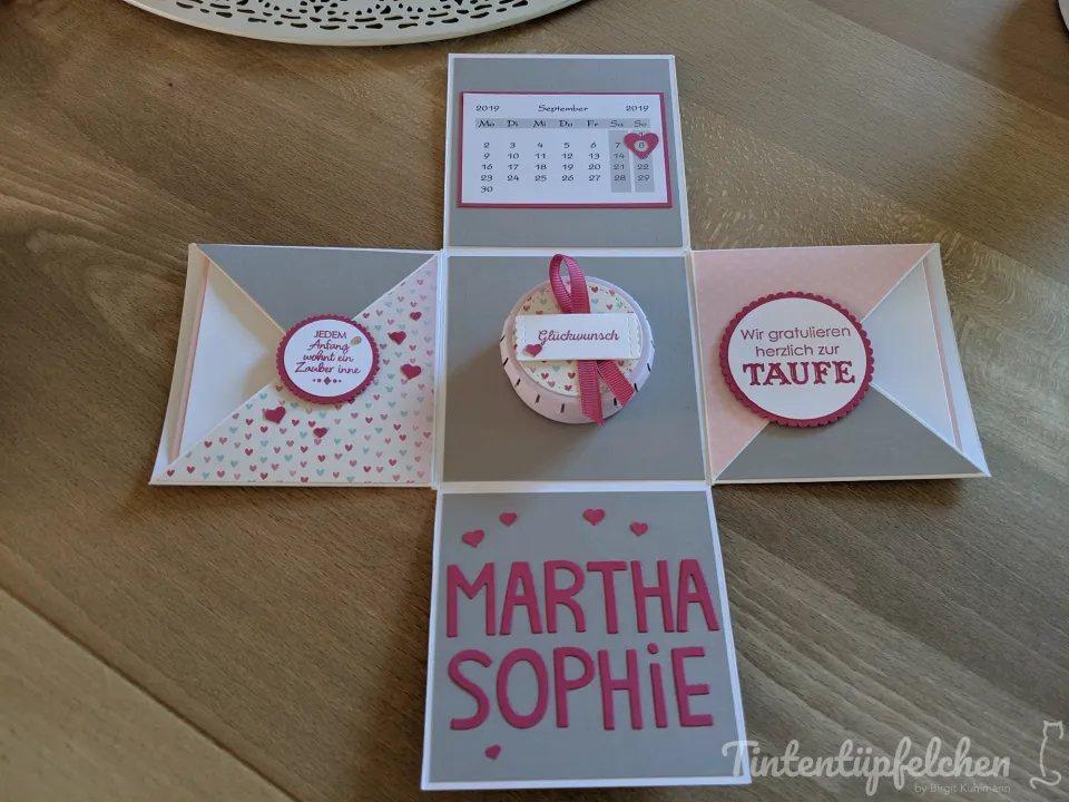 Eine Explosionsbox zur Taufe mit dem Kalenderblatt September 2019, dem Namen MARTHA SOPHIE und den Sprüchen "JEDEM Anfang wohnt ein Zauber inne" und "Wir gratulieren herzlich zur Taufe".