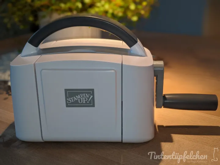 Eine weiße Stanzmaschine mit einem grauen Griff und dem Stampin' Up!-Logo.
