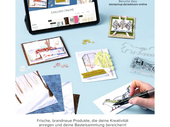 Ein Tablet zeigt den Online-Shop von StampinUp mit Bastelprojekten, darunter Karten mit winterlichen Bäumen und einem goldenen Streifen. Eine Hand färbt ein gestempeltes Bild eines Schlittenfahrers mit einem schwarzen Stift aus. Im Hintergrund liegen weitere Materialien wie Schneeflocken, Stempel und Schablonen auf hellblauem Papier.
